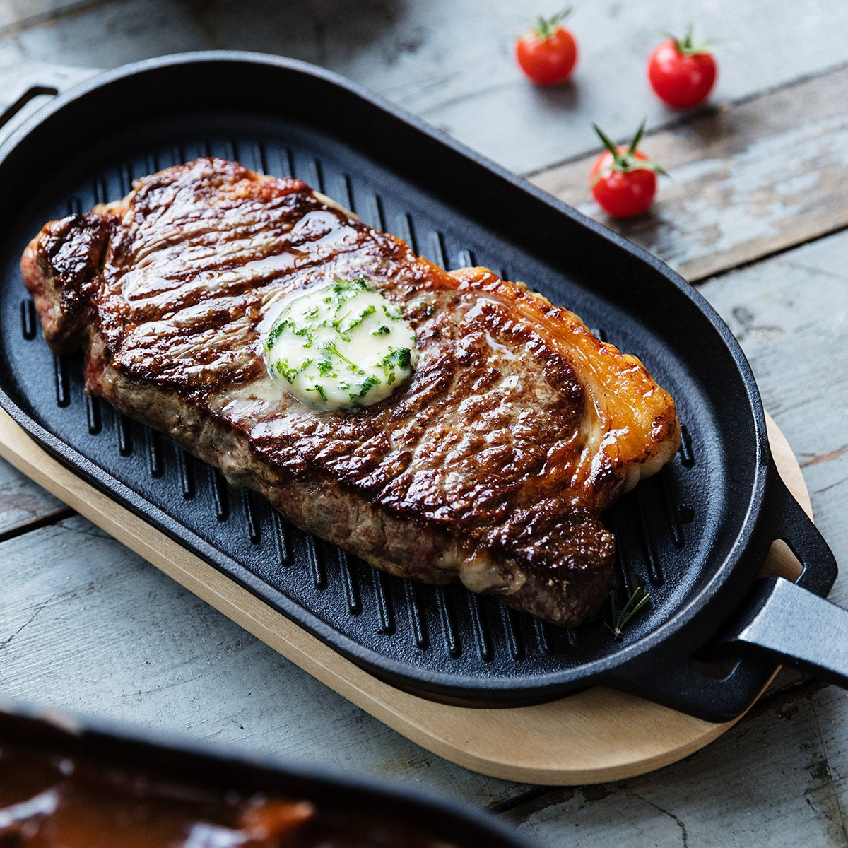 Grillpfanne aus Gusseisen mit Holz-Untersetzer